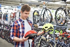 Mann wählt richtige Fahrradhelm-Größe