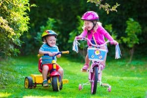 Geschwister fahren Fahrrad mit Helm