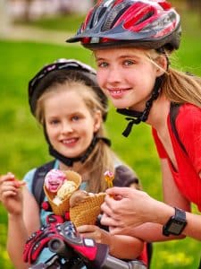 Mädchen mit Helm essen Eis
