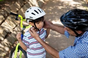 Vater justiert Fahrradhelm von Sohn